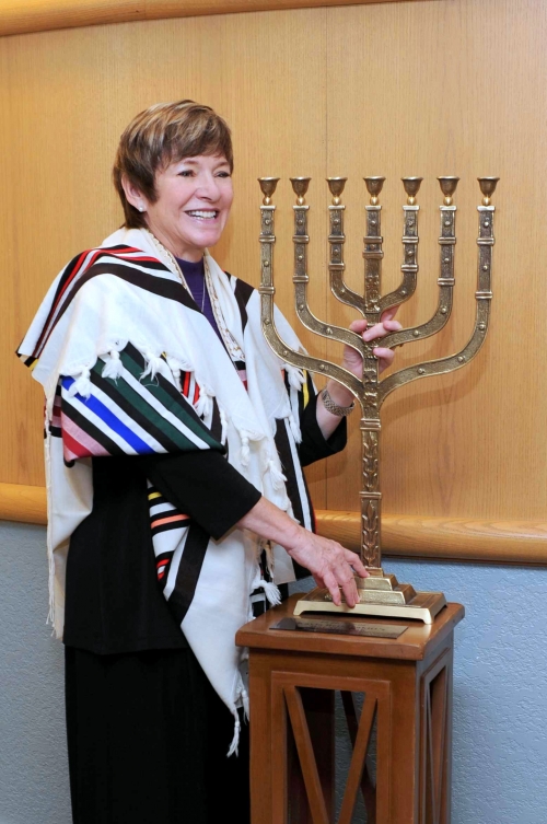 Rabbi Barbara Aiello stands with synagogue menorah as she welcomes Italy&#039;s first modern rabbinic intern to the Calabrian synagogue, Ner Tamid del Sud in Serrastretta, Italy.