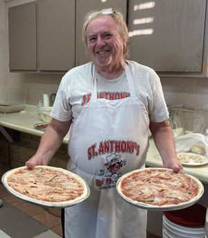 Dan Noday of Youngstown prepares to hand off two Brier Hill pizzas that are ready to go in the oven.