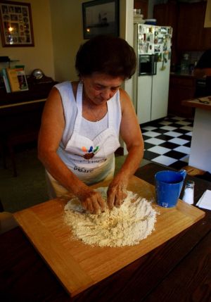 Clelia at work mixing flour and water for bread or pizza.