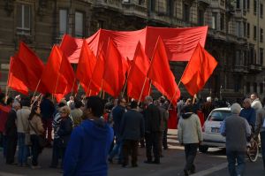 Mixed groups of people with banners and flags in parades on the main street to celebrate the international Labor Day on May 1.