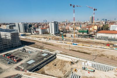 Milan, Italy - March 19, 2025: Construction site of the Olympic Village for the 2026 Winter Games in Porta Romana district, Milan, with cranes, modern residential buildings,  railway tracks, and city